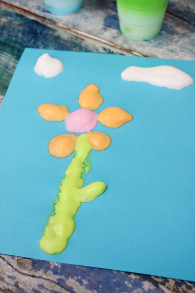 A photo of a picture of flowers and clouds made with puffy paint. - Cultivating Brilliant Minds puffy paint used to make a picture
