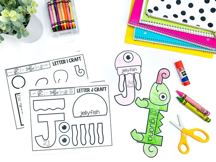 A photo of alphabet crafts. There are two jellyfish crafts for the letter j and 2 iguana crafts for the letter i.