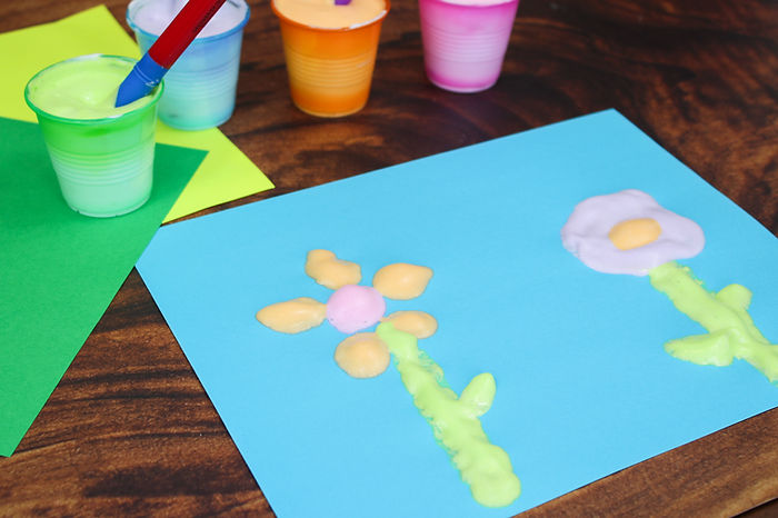 A photo of a picture of flowers made with puffy paint.