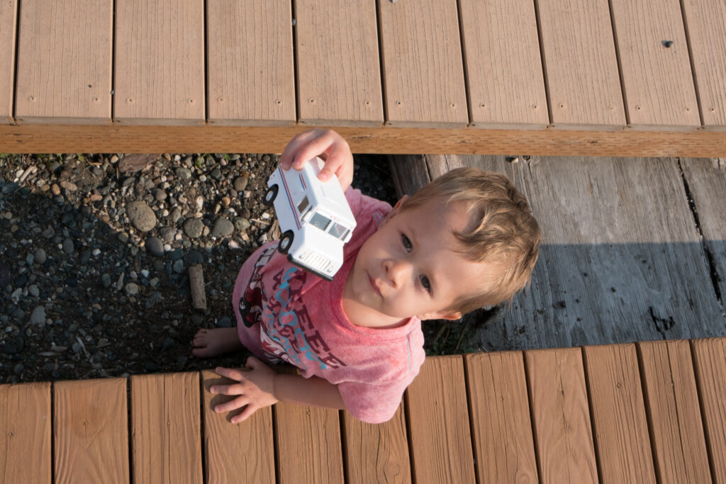 A-Z Summer Words - Cultivating Brilliant Minds a kid holding a toy trucks