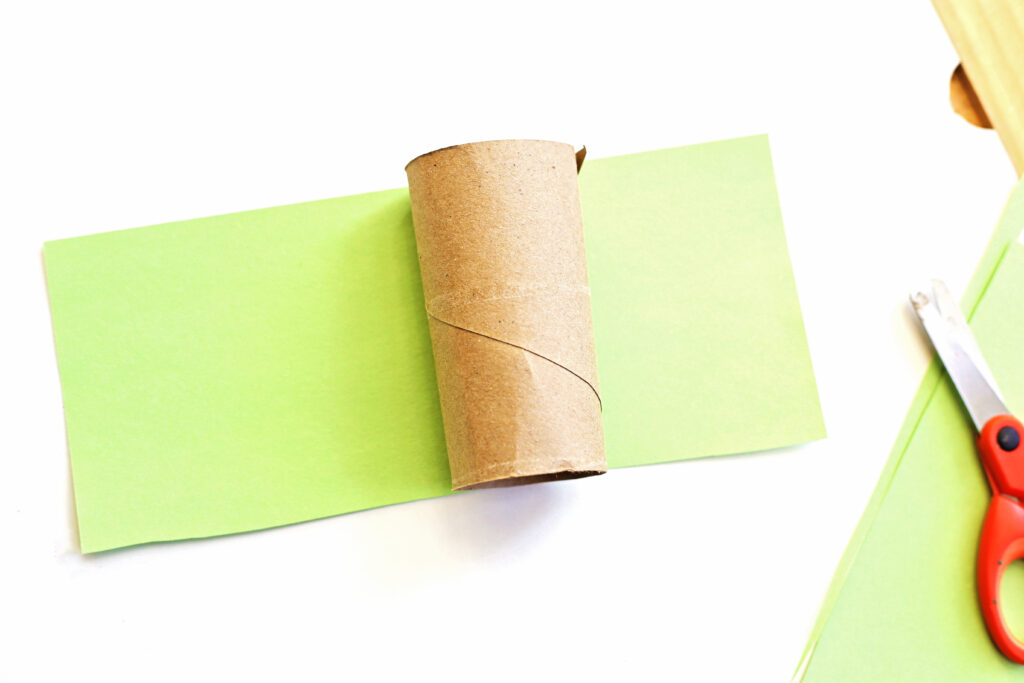 Cut Strip of Green Paper - Cultivating Brilliant Minds wrapping the toilet paper roll with construction paper