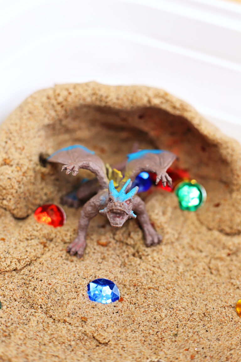 a Dragon Sensory Bin with kinetic sand and gems