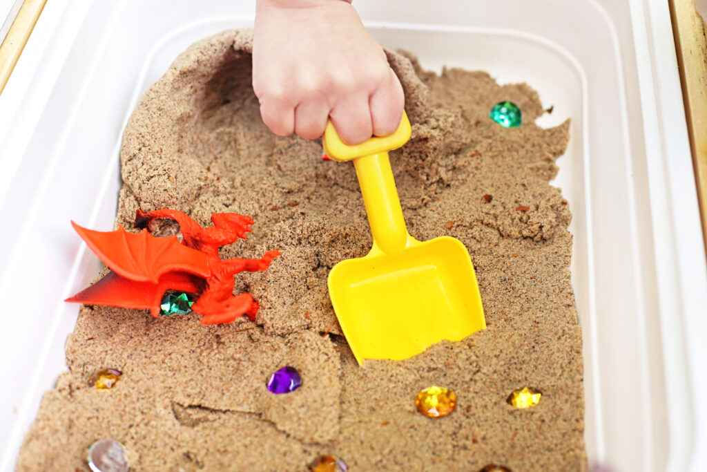 Dragon_s Lair Sensory Bin 4 - Cultivating Brilliant Minds Kid playing in the Dragon's Lair Sensory Bin