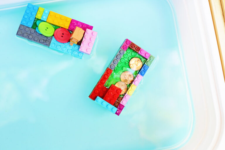 legos made into a boat with pennies on it in water