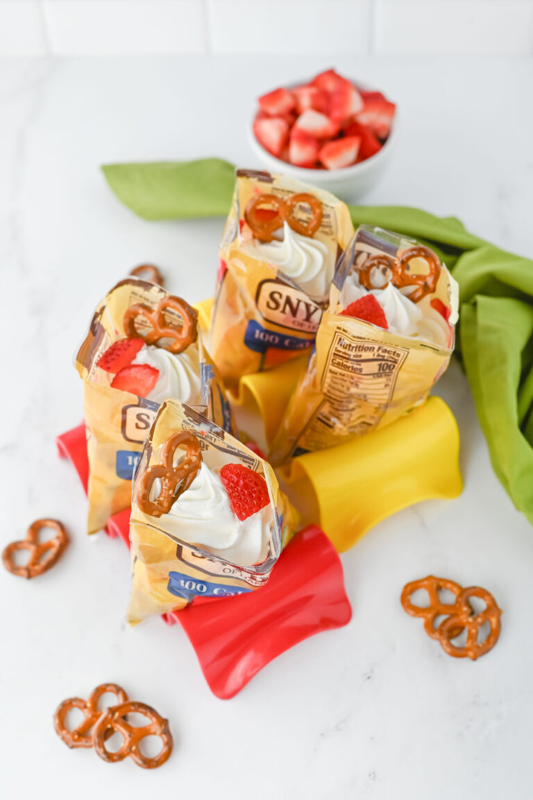 a bag of pretzels with whipped cream and strawberries