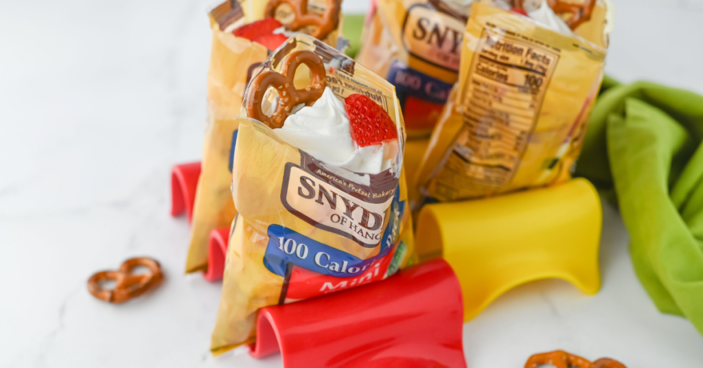 a bag of pretzels with whipped cream and strawberries