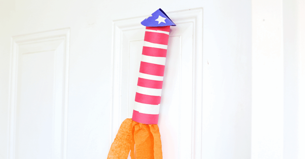 a construction paper rocket craft with orange streamers at the bottom