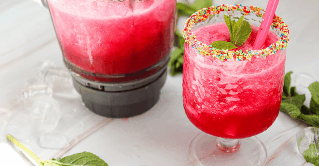 a watermelon slushie with colored candies along the rim