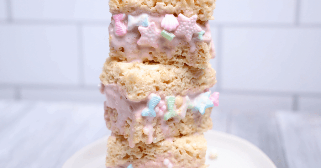 rice krispie treats with ice cream in the middle and mermaid sprinkles on the outside
