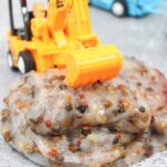 Pebble Slime Recipe - Cultivating Brilliant Minds slime made with pebbles in it with a construction backhoe on top
