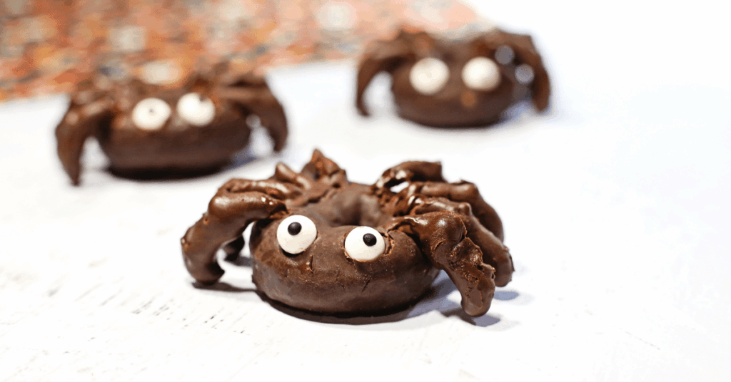 donuts with chocolate covered pretzel legs and candy eyes to look like a spider