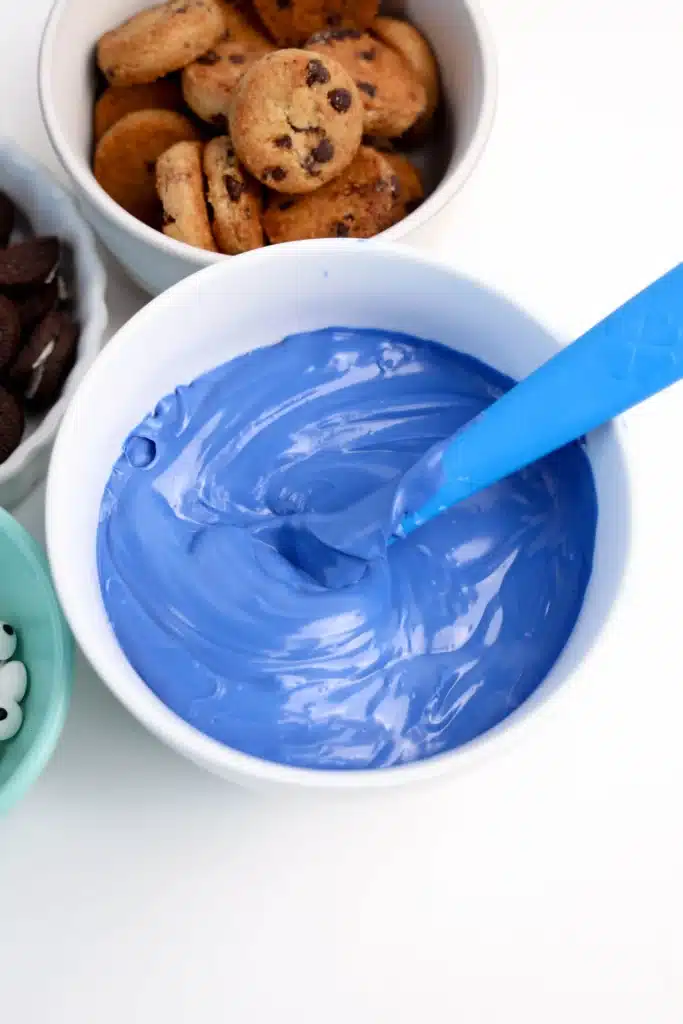 Cookie Monster Bark - Cultivating Brilliant Minds blue candy melts melted in a bowl with a blue spoon