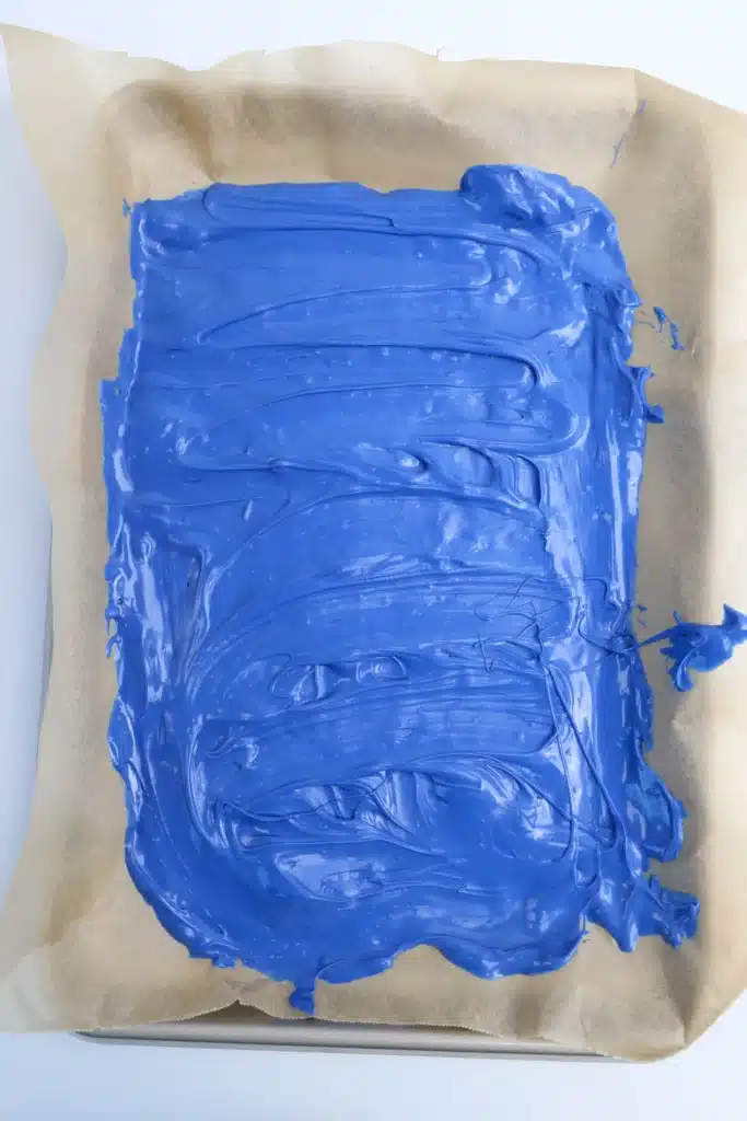 Cookie Monster Bark - Cultivating Brilliant Minds melted blue candy melts spread on a piece of parchment paper