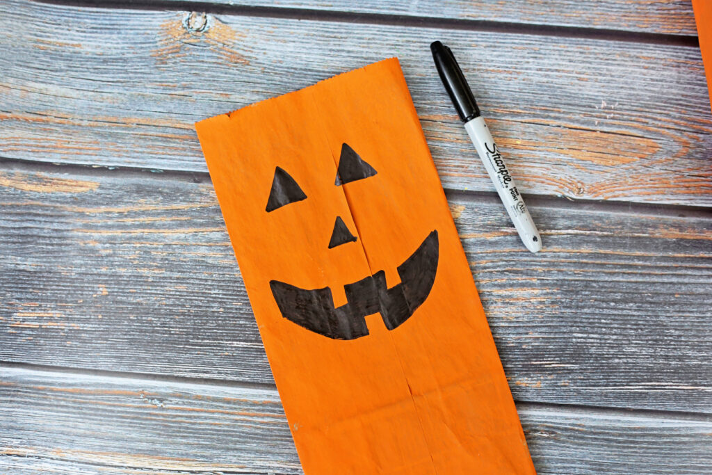 Draw Jack o Lantern Face - Cultivating Brilliant Minds add spooky faces using a black marker