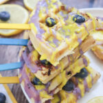 blueberry lemon waffle pops on sticks stacked on top of each other