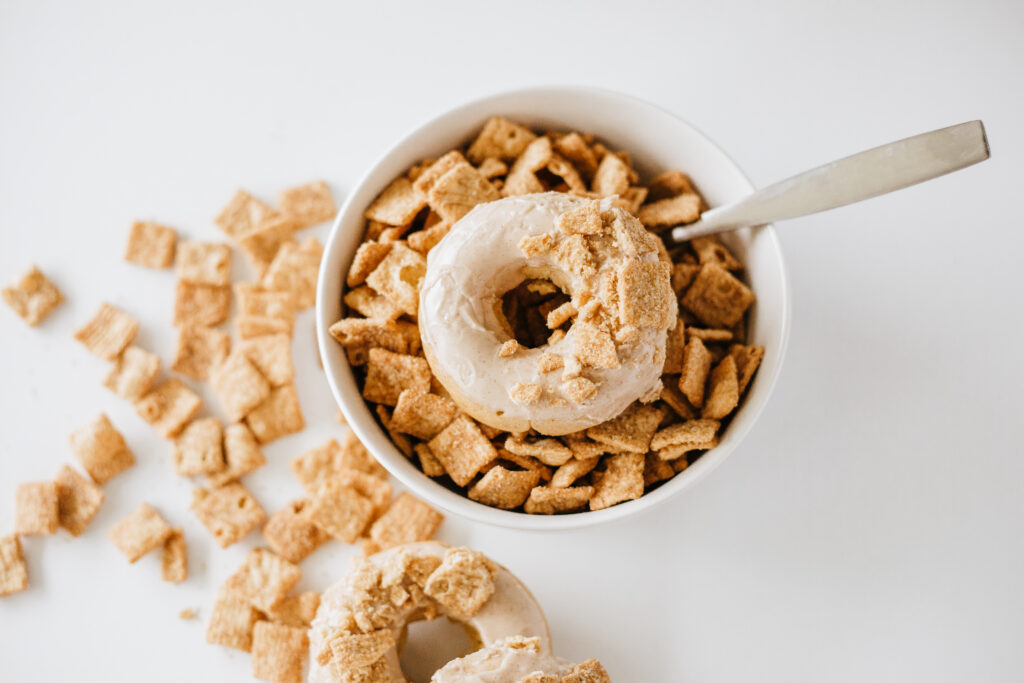 cinnamon toast crunch donuts-03 - Cultivating Brilliant Minds cinnamon toast crunch donut onto of a bowl of cinnamon toast crunch
