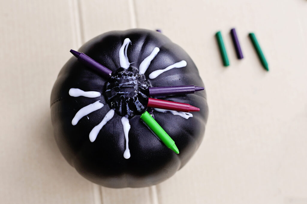 Glue crayons on pumpkin 1 - Cultivating Brilliant Minds the black pumpkin with glued crayons to the top