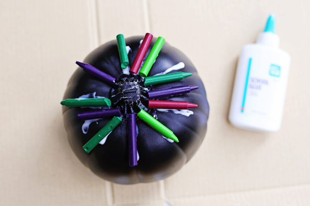 Glue crayons on pumpkin 2 - Cultivating Brilliant Minds the black pumpkin with glued crayons to the top