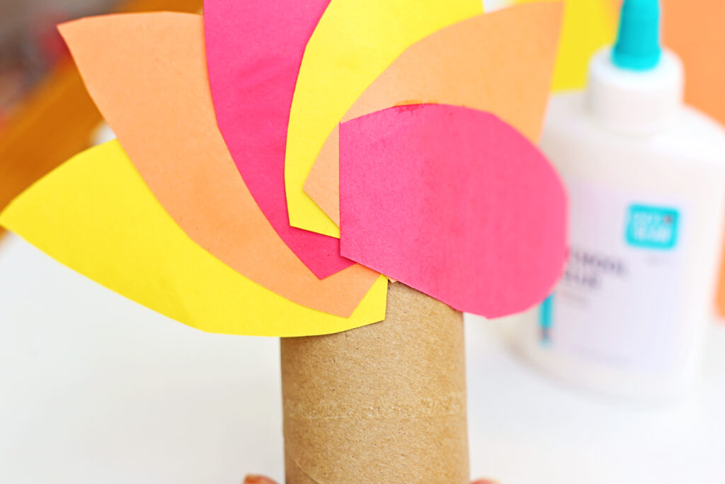 Glue feathers to back of toilet paper roll - Cultivating Brilliant Minds a close up of the feathers glued on the toilet paper roll