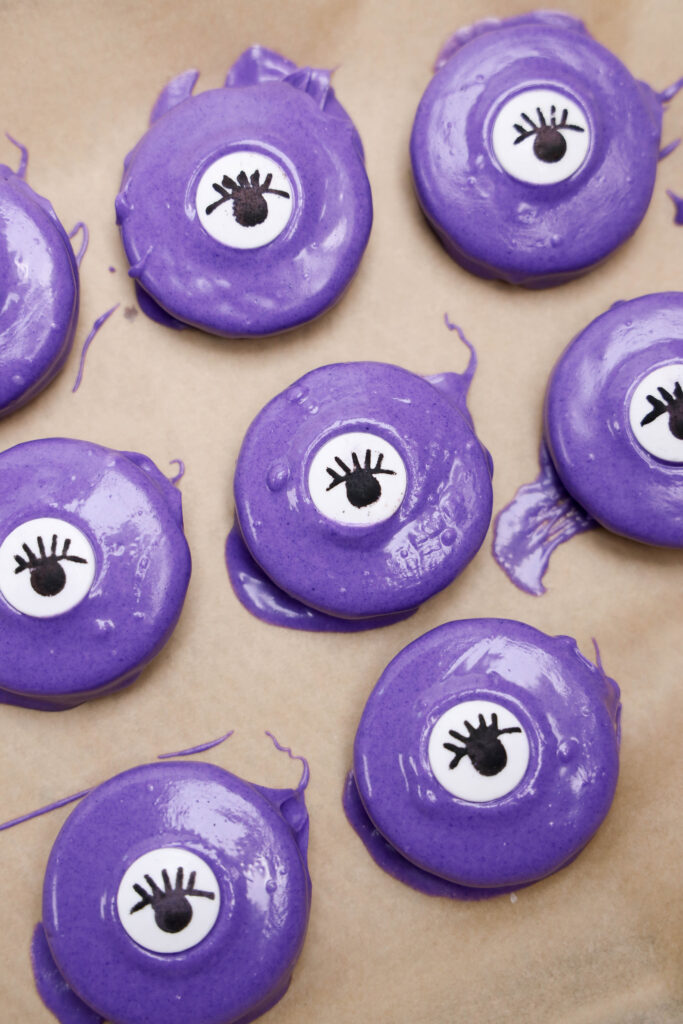 Monster Oreos - Cultivating Brilliant Minds purple chocolate covered oreos with an eye candy in the middle