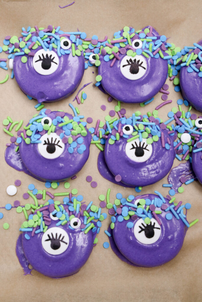 Monster Oreos - Cultivating Brilliant Minds purple chocolate covered oreos with an eye candy in the middle and sprinkles on the top