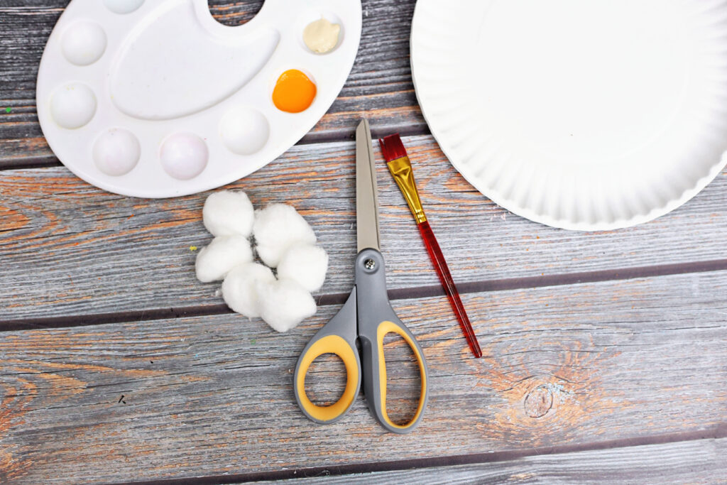 Thankful Pumpkin Pie Craft Supplies - Cultivating Brilliant Minds Thanksgiving craft for kids supplies showing paint, scissors, paint brush, paper plate, and cotton balls