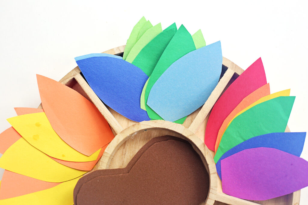 Turkey in Disguise Craft 3 - Cultivating Brilliant Minds construction paper feathers on this Turkey in Disguise Decorating Tray