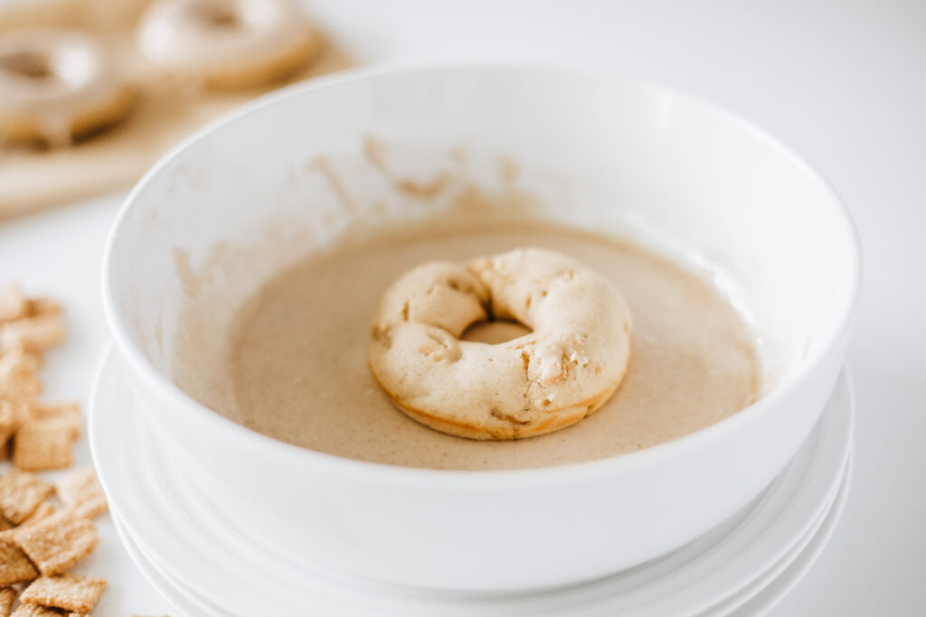 cinnamon toast crunch donuts-21 - Cultivating Brilliant Minds dipping the donut in the glaze