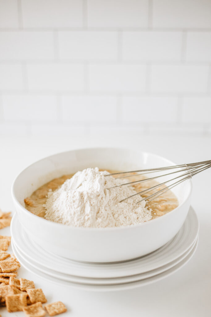 cinnamon toast crunch donuts-33 - Cultivating Brilliant Minds dry and wet ingredients in a bowl with a whisk