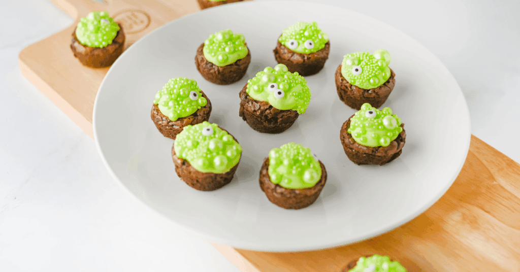 brownie bites with green icing and sprinkles to look like a bubbling cauldron