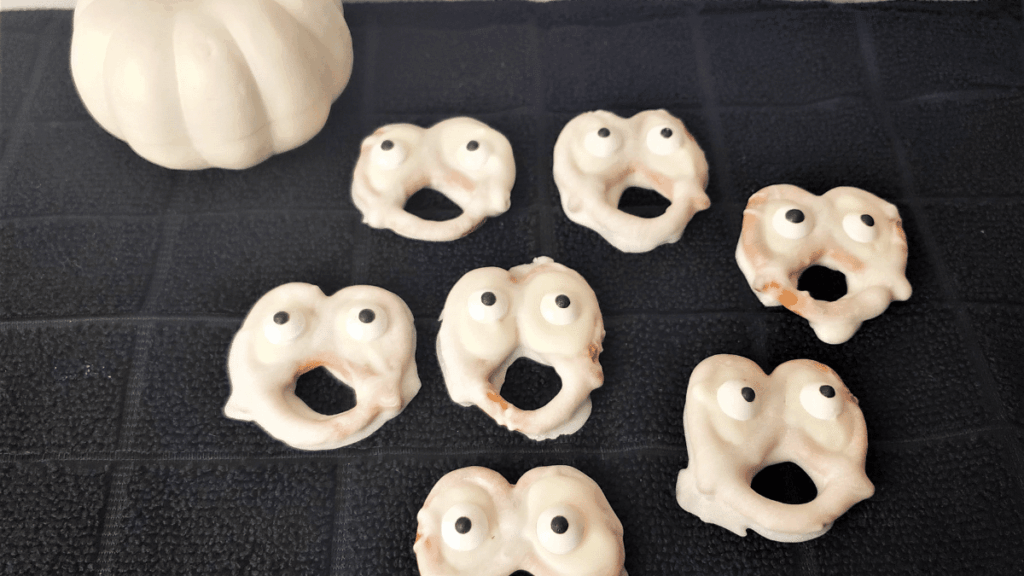 pretzels dipped in white chocolate with candy eyes