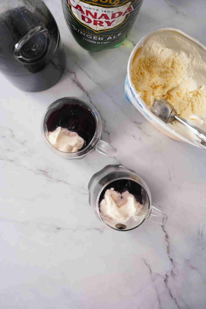 Black Halloween Punch For Kids - Cultivating Brilliant Minds Black halloween punch with ice cream on top in a clear ghost mug