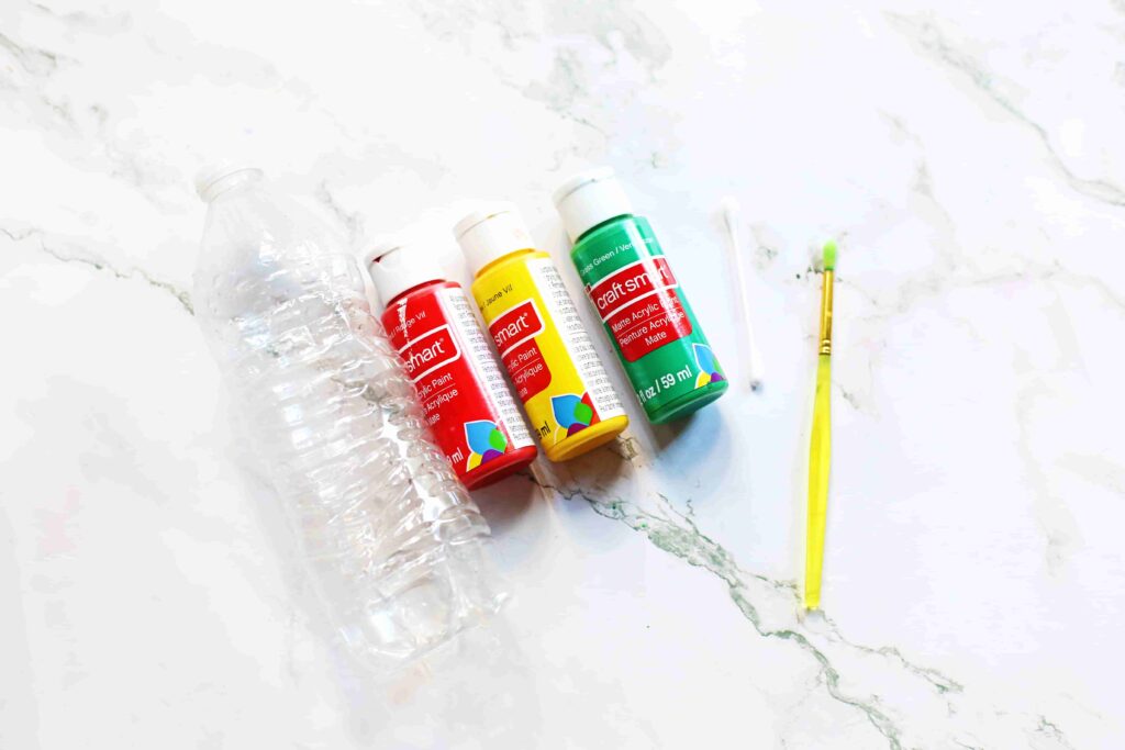 Christmas Tree Bowling - Cultivating Brilliant Minds empty water bottle, paint brush, and red, yellow, and green paint