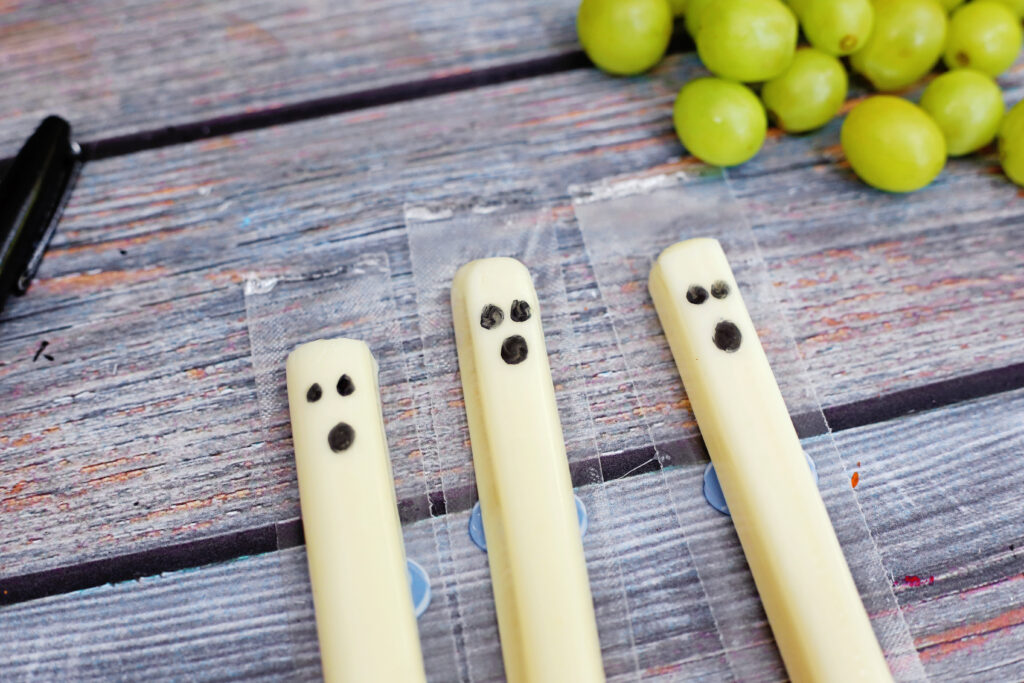 Healthy Halloween Snacks - Cultivating Brilliant Minds string cheese with ghost faces drawn on