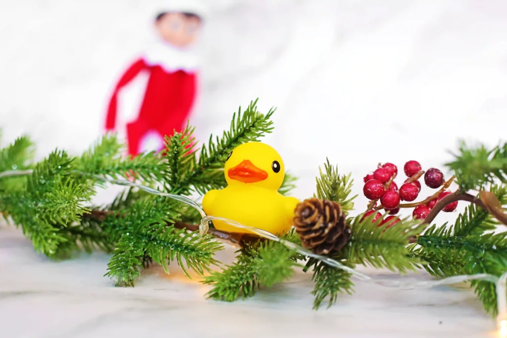 Elf on the Shelf Idea - Cultivating Brilliant Minds an elf on the shelf next to a duck with a sign that reads "I ducked the halls! Can you find all 10 ducks?"