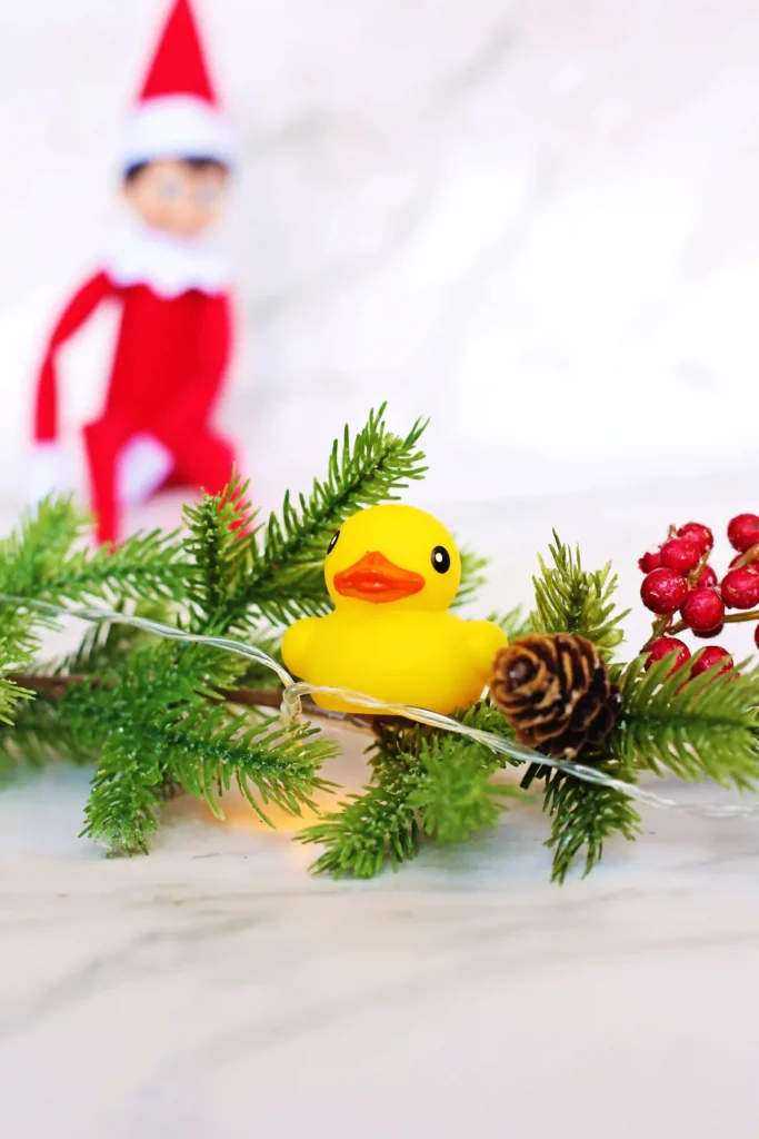 Elf on the Shelf Idea - Cultivating Brilliant Minds an elf on the shelf next to a duck with a sign that reads "I ducked the halls! Can you find all 10 ducks?"