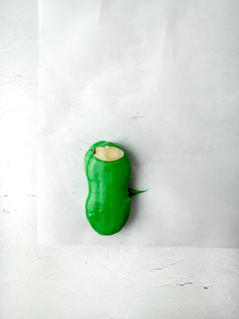 Nutter Butter Zombie Fingers - Cultivating Brilliant Minds nutter butter cookie dipped in green chocolate with an almond slice on top