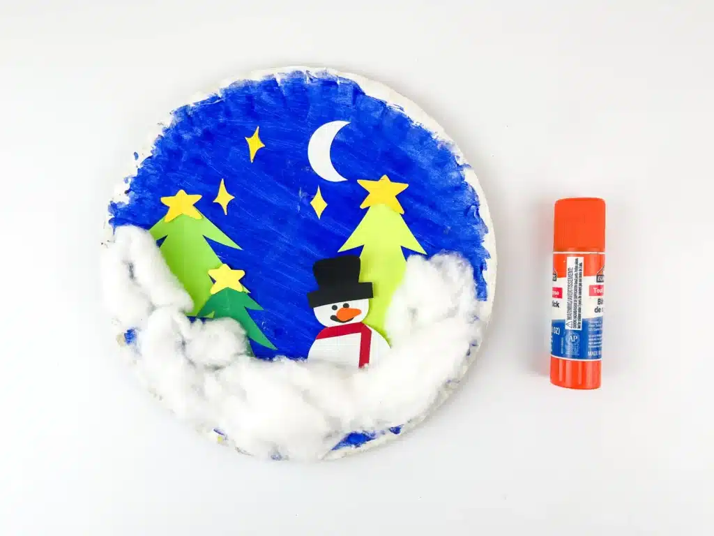 Snowglobe Paper Plate Craft - Cultivating Brilliant Minds a paper plate decorated with construction paper trees and cotton to look like snow