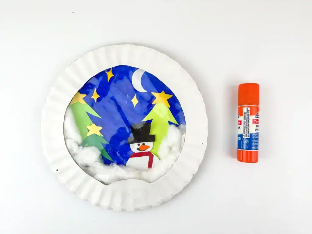 Snowglobe Paper Plate Craft - Cultivating Brilliant Minds a paper plate craft that looks like a snowglobe with a snowman and trees inside
