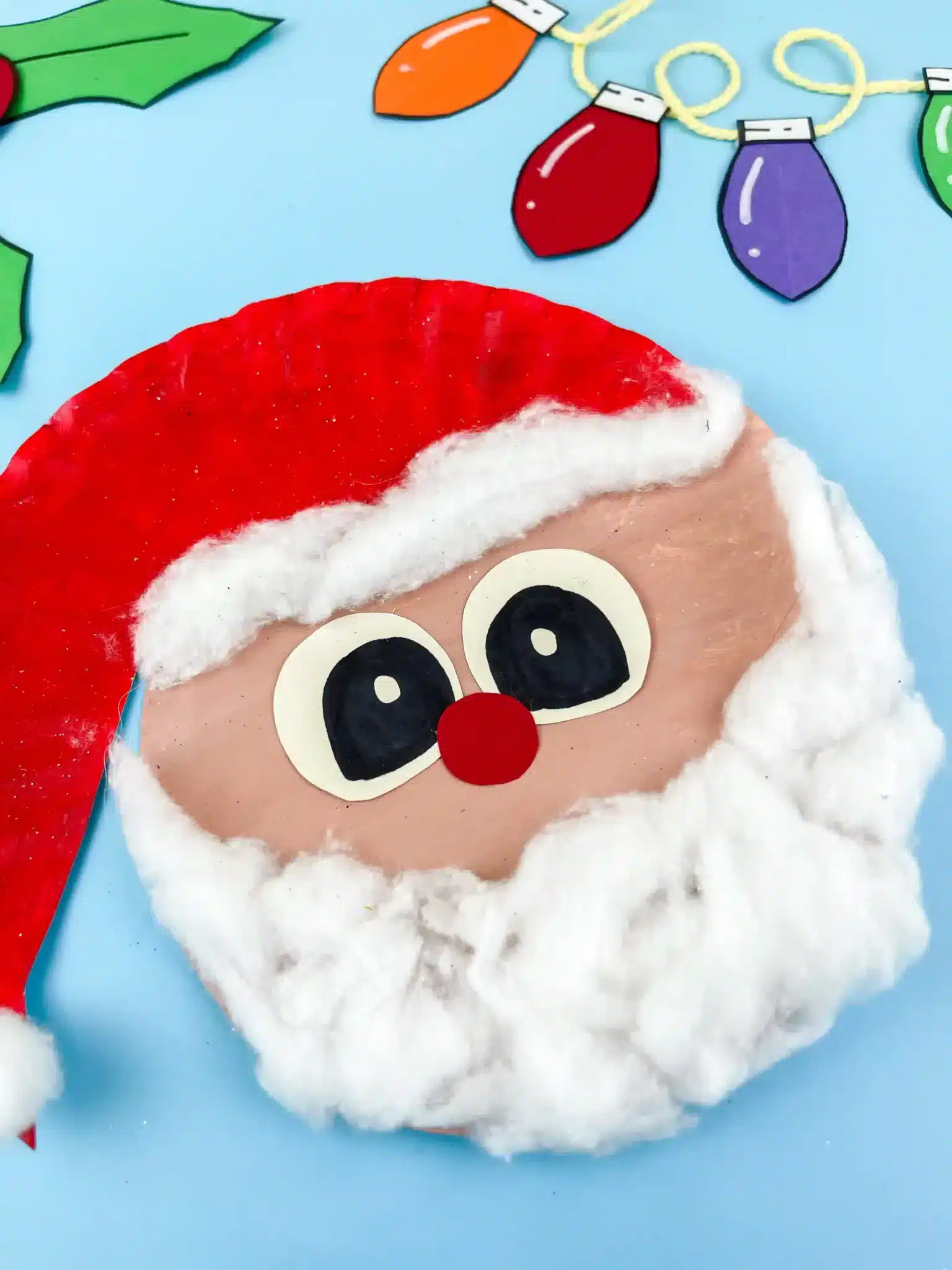 a paper plate painted and decorated to look like santa