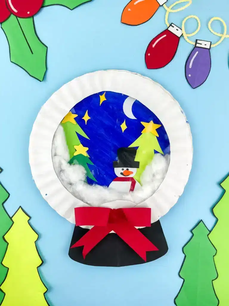 Snowglobe Paper Plate Craft - Cultivating Brilliant Minds a paper plate craft that looks like a snowglobe with a snowman and trees inside