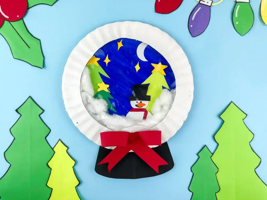 Snowglobe Paper Plate Craft - Cultivating Brilliant Minds a paper plate craft that looks like a snowglobe with a snowman and trees inside