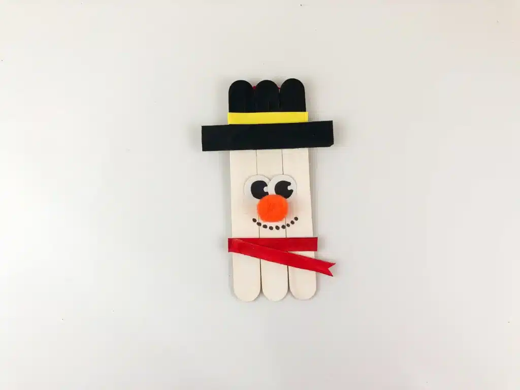 Snowman Popsicle Stick Ornament - Cultivating Brilliant Minds popsicle sticks glued together and decorated to look like a snowman to make a snowman popsicle stick ornament for the tree