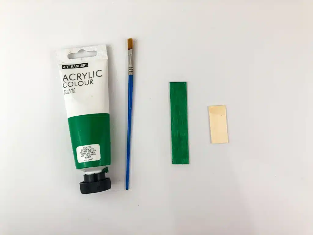 Christmas Tree Popsicle Stick Ornament - Cultivating Brilliant Minds painting a popsicle stick green