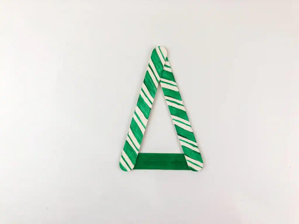 Christmas Tree Popsicle Stick Ornament - Cultivating Brilliant Minds popsicle sticks painted with green stripes, glued together to form a triangle