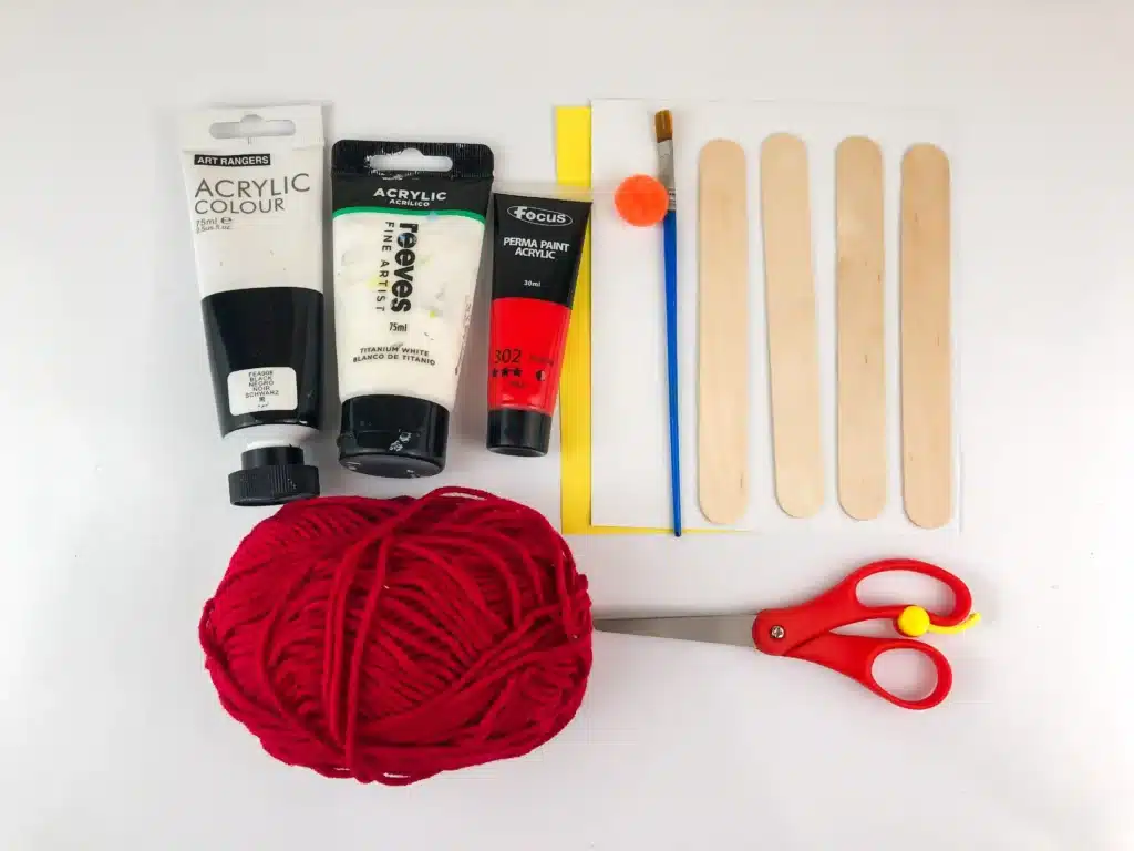 Snowman Popsicle Stick Ornament - Cultivating Brilliant Minds paint, paintbrush, popsicle sticks, red yarn, construction paper, an orange pom pom, and scissors