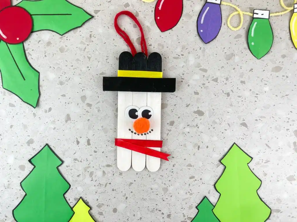 Snowman Popsicle Stick Ornament - Cultivating Brilliant Minds popsicle sticks glued together and decorated to look like a snowman to make a snowman popsicle stick ornament for the tree