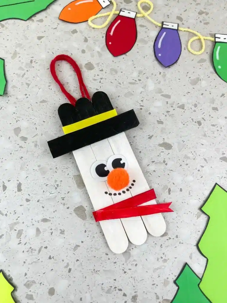 Snowman Popsicle Stick Ornament - Cultivating Brilliant Minds popsicle sticks glued together and decorated to look like a snowman to make a snowman popsicle stick ornament for the tree