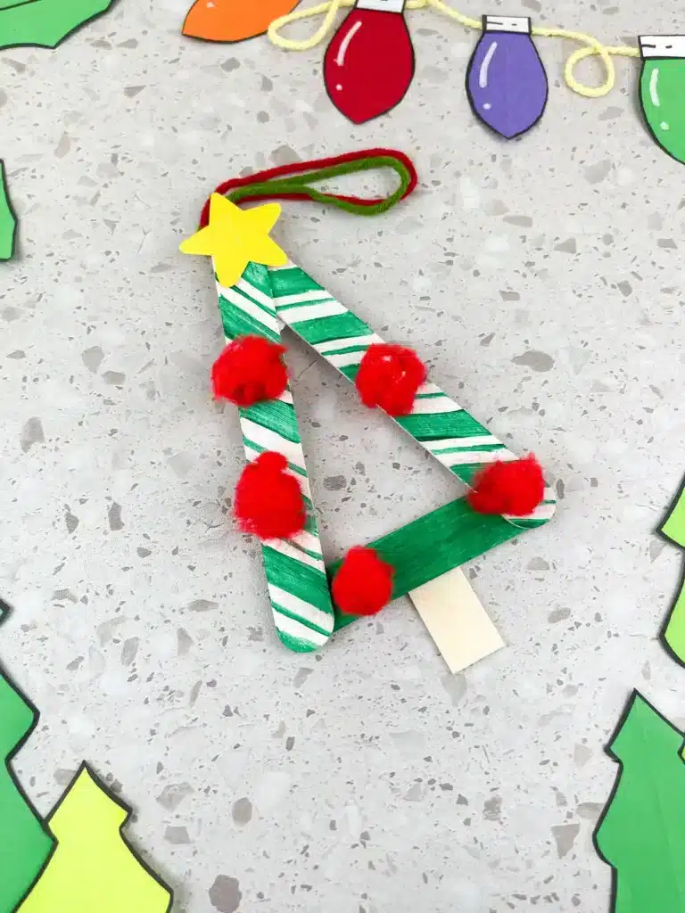 Christmas Tree Popsicle Stick Ornament - Cultivating Brilliant Minds a popsicle stick christmas ornament decorated to look like a tree