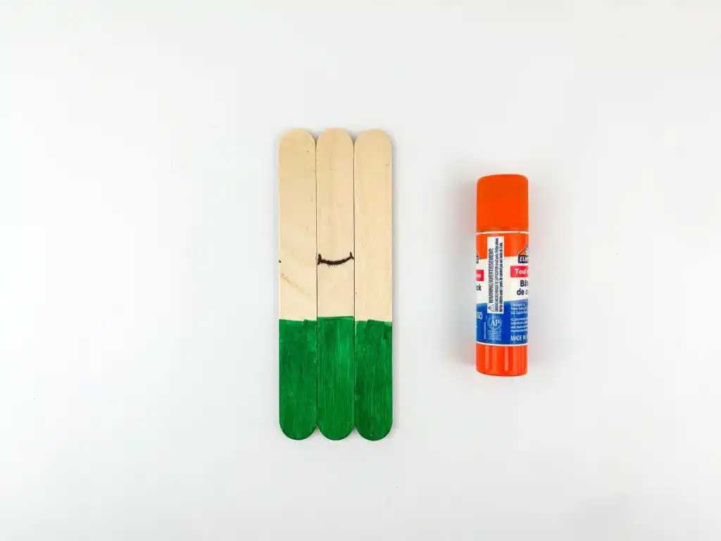 three popsicle sticks glued together with the bottom painted green